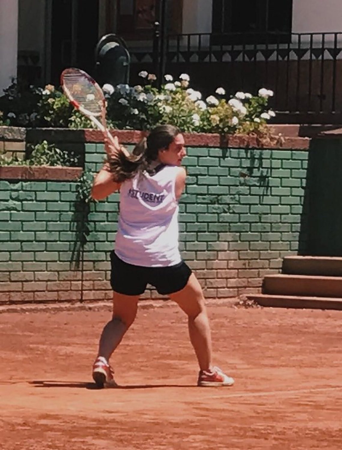 Camila hitting a backhand on clay